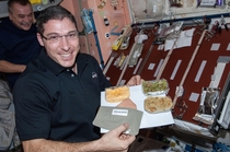 NASA astronaut Michael Hopkins Expedition  flight engineer poses for a photo with his Thanksgiving meal in the Unity node of the International Space Station Nov 