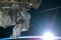 NASA astronaut Terry Virts Flight Engineer of Expedition  works to complete a cable routing task while the sun begins to peek over the Earths horizon on the International Space Station - 
