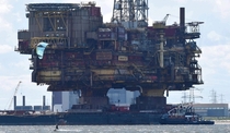 Oil rig being floated down a river for decommissioning