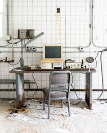 Old desk with a bunch of outdated testing equipment in an abandoned laboratory 