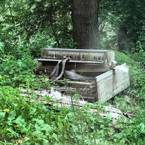 Old piano along a creek side road