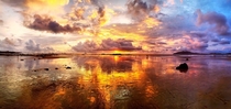 Pano shot  Tamarindo Costa Rica Sunset reflected against the receding tide 