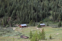 Partially reconstructed gold sifter cabins in a valley outside of Aspen CO With the Continental Divide in the background