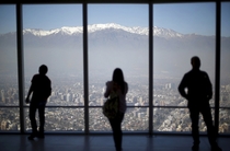 People look out to the Los Andes mountain range next to the city from a rooftop of a commercial center in Santiago Chile Ivan Alvarado 
