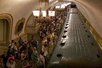 People waiting for subway train to come to a halt incredibly ornate Moscow subway station  Summer 