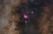 photograph captured the red planet passing below two notable nebulae -- cataloged by the th century cosmic registrar Charles Messier as M and M M upper right of center the Trifid Nebula presents a striking contrast in redblue colors and dark dust lanes 
