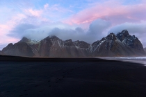 Pink hues stretch above the mountains of Vestrahorn Iceland   x 