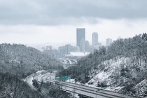 Pittsburgh PA peaking through the mountains during a morning snowstorm