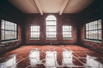 Rain soaked red brick sun room in an abandoned asylum 