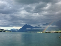 Rainbow on the hills across a lake in Giswil Switzerland 