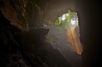 Rays of light flood a large natural entrance to this cave in the northern district of Pang Mapha in Thailand - Photo by John Spies 