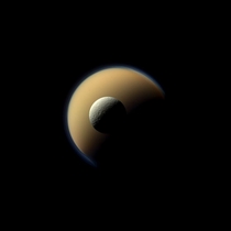 Rhea in front of Titan which is biggest moon of Saturn Taken by Cassini