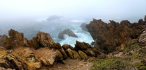 Rocky precipice on the Pacific Coast as the mornings marine layer comes ashore 
