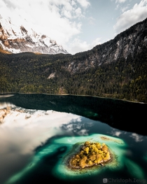 Small island in Eibsee just below the Zugspitze Germanys highest mountain 
