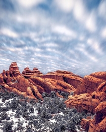 Snow at Arches NP - Moving clouds above mimic the lines and shapes of the red rocks below 