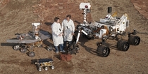 Spacecraft engineers stand with three generations of Mars rovers JPLs Mars Yard testing area 