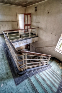 Staircase in abandoned living quarters in an RAF Base Decay in this entire building was set perfectly for photos the wallpaper just peeling off of the walls and no graffiti 