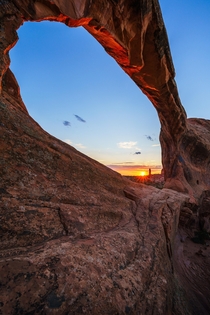 Sun setting through Double O Arch Arches Ntl Park Utah -