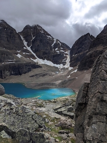 Sunlight briefly breaks through the clouds illuminating the turquoise colours of this alpine lake in the Canadian Rockies 