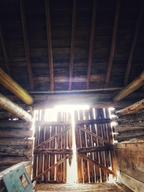 Sunlight through the doors of an abandoned barn