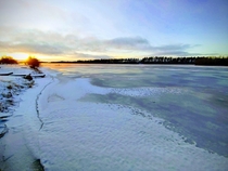 Sunrise and Aurora Borealis colouring the nearly frozen Ume River - Ume Sweden 
