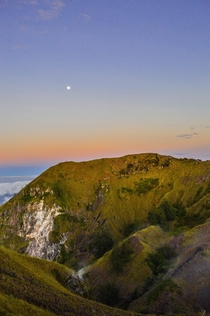 Sunrise on Mt Batur Indonesia while the moon still peaks through 