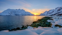 Sunset in the ocean between the mountains out in the fjord Ersfjordbotn Troms Fylke Norway  by John A Hemmingsen