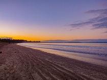 Sunset over a beach in New Zealand North Shore 
