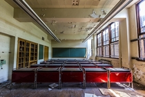 Symmetrical red desks in an abandoned Detroit school Unfortunately the school was burned to the ground accidentally by scrapping thieves that week 