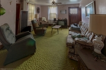Tacky carpet and old furniture in an almost fully intact living room in an abandoned house in Ontario Canada OC -   