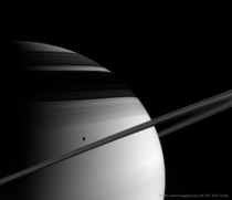 The ice moon Tethys passes in front of Saturns rings photo taken in  from the Cassini spacecraft 