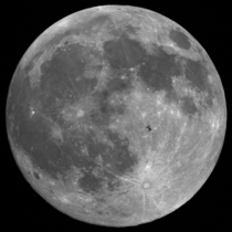 The International Space Station in front of the full moon