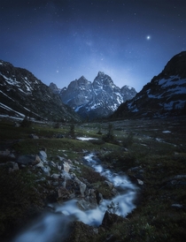 The Milky Way and Jupiter rising over the Tetons on a moonlit night 