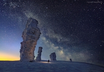 The Milky Way seen over the Manpupuner or Seven Strong Men rock formations in northern Russia photographed in February  by Sergei Makurin 