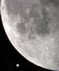 The Moon with Jupiter and  of its moons in the background 