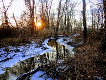 The sun sets over a thawing creek on a chilly winter day - Chester County PA 