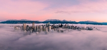 The Vancouver skyline floating in the clouds at sunrise