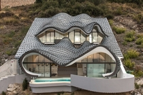 This cliff-side home designed by GilBartolome Architecture showcases organic forms with zinc roofs located in Salobrea on the Granada coast Spain 
