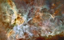 This image released for Hubbles th anniversary shows a region of star birth and death in the Carina Nebula The nebula contains at least a dozen brilliant stars that are  to  times the mass of our Sun 