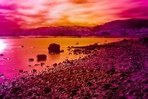 This is an infra red view of a volcanic lake in New Zealand Rotorua You can see a bright orange area in the foreground where a thermal vent is bubbling up through the ground The water here is boiling as it comes out 