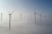 Turbines poke above the morning fog at a wind farm in Jacobsdorf Germany on Feb  