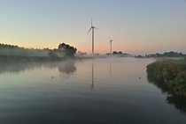 Wind turbines and highway in early morning sunrise and mist - The Netherlands 