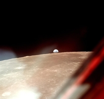Window view from Apollo  of Earth rising over the Moon 