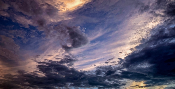  August  crescent moon shining through dramatic skies over southeast Texas