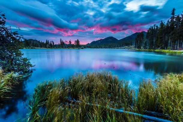 A dramatic and vibrant sunrise in Sprague Lake in Rocky Mountain National Park x