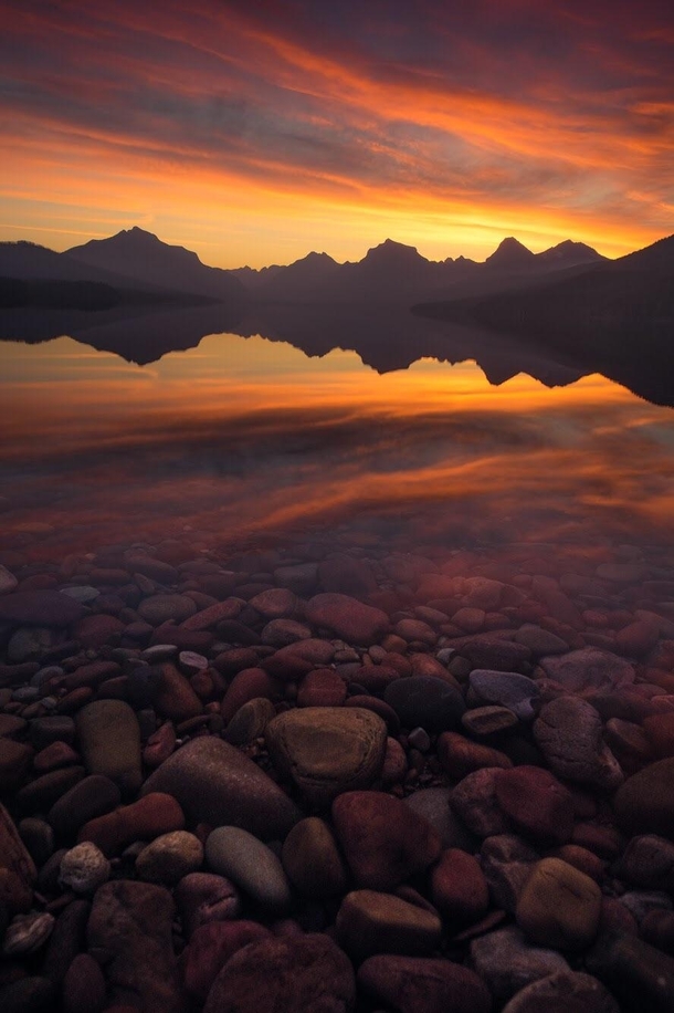 A fiery sunrise over Lake McDonald in Glacier National Park MT I cant wait to backpack in the park next summer  mattymeis