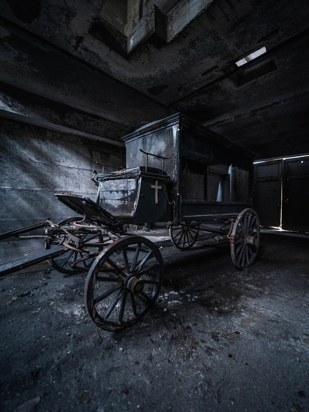 A forgotten hearse chariot hidden inside a morose barn Its final destination RIP 