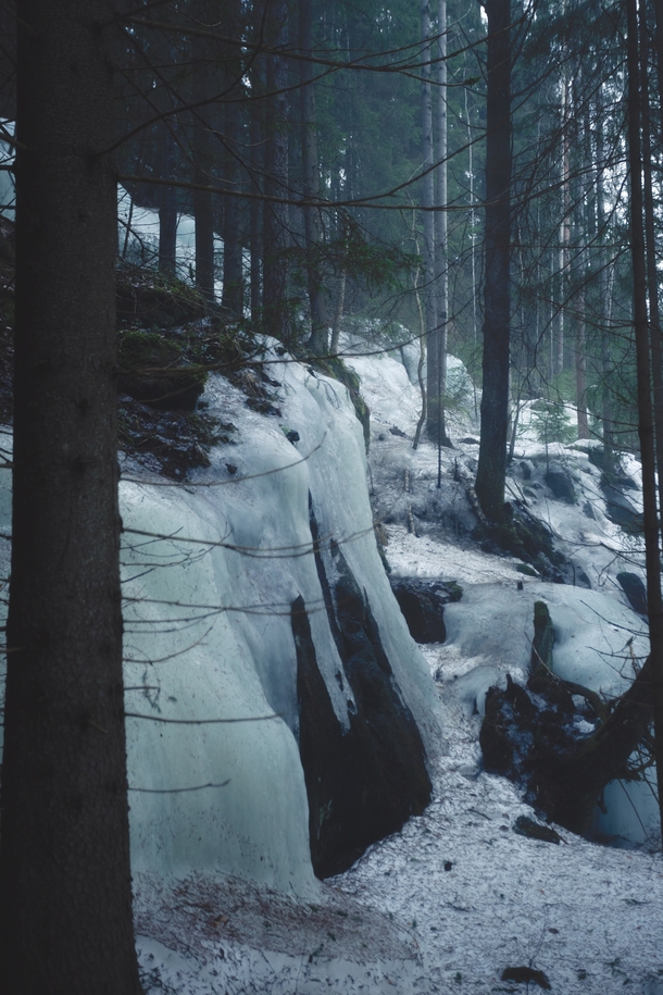 A frozen waterfall in the misty woods of central Finland 