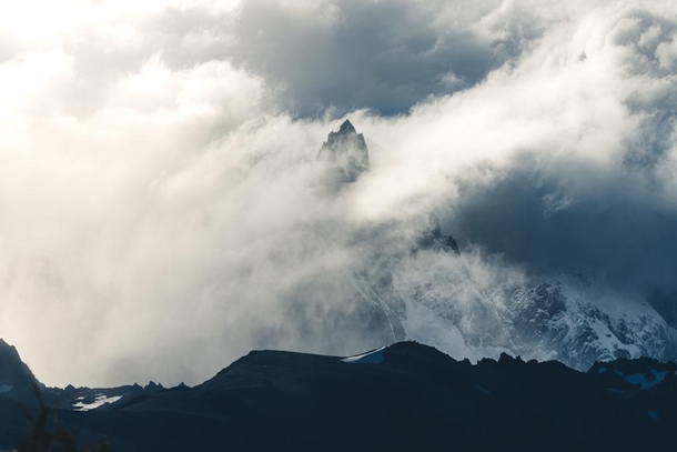 A peak in Patagonia breaks out amid the clouds 