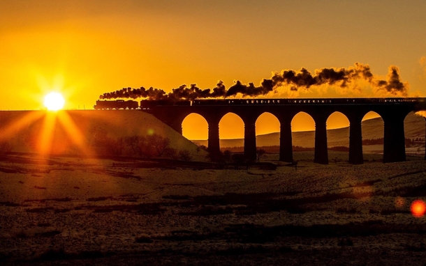 A preserved British steam locomotive travelling over Ribblehead Viaduct England x-post from rtrains